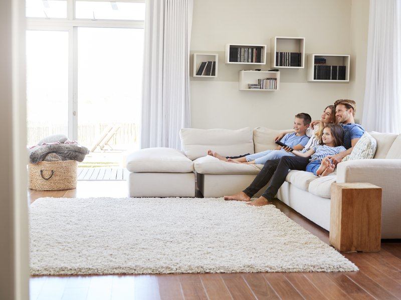 young family sitting on sofa in living room